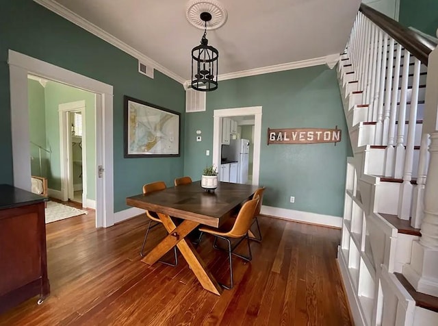 2413 34th St, Galveston, TX 77550 - dining area with crown molding, dark wood finished floors, stairway, and a chandelier