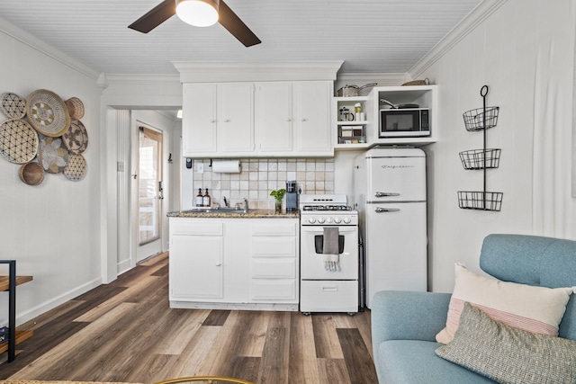 2413 34th St, Galveston, TX 77550 - kitchen with white gas range oven, freestanding refrigerator, black microwave, dark wood-style floors, and crown molding