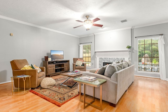 6 Heathstone Pl, The Woodlands, TX 77381 - living area with wood finished floors, a premium fireplace, ceiling fan, crown molding, and a textured ceiling