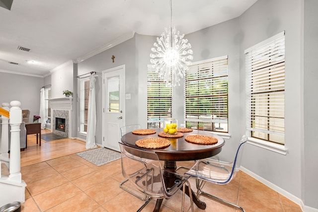6 Heathstone Pl, The Woodlands, TX 77381 - dining area featuring light tile patterned flooring, crown molding, a fireplace, and a chandelier