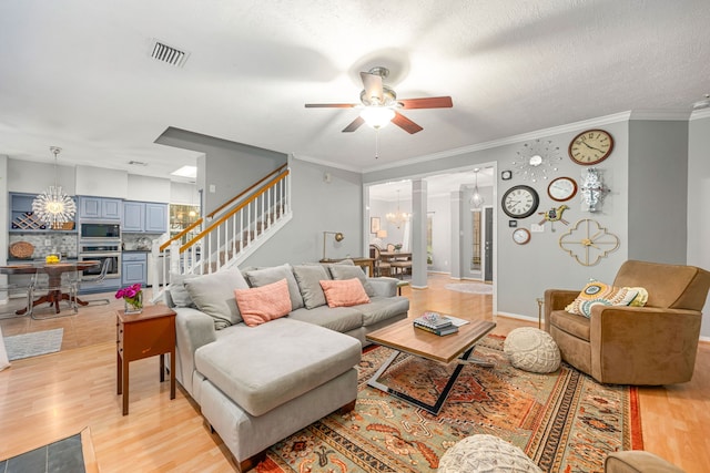 6 Heathstone Pl, The Woodlands, TX 77381 - living room featuring a chandelier, light wood-style flooring, stairway, ceiling fan, and ornamental molding