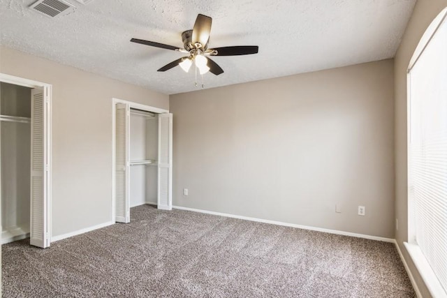 4710 N Cashel Cir, Houston, TX 77069 - unfurnished bedroom with two closets, carpet floors, a textured ceiling, a ceiling fan, and multiple windows