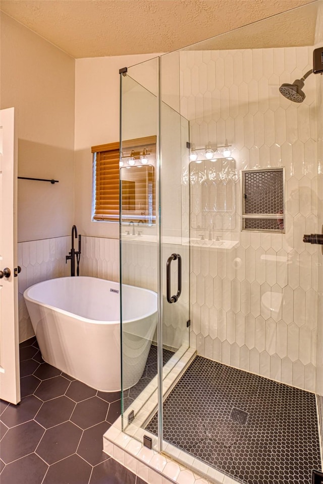14715 Cobre Valley Dr, Houston, TX 77062 - full bathroom featuring a stall shower, tile patterned flooring, a soaking tub, a wainscoted wall, and a textured ceiling