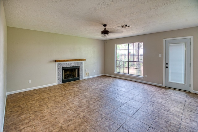 14715 Cobre Valley Dr, Houston, TX 77062 - unfurnished living room with a fireplace, a textured ceiling, ceiling fan, and tile patterned floors