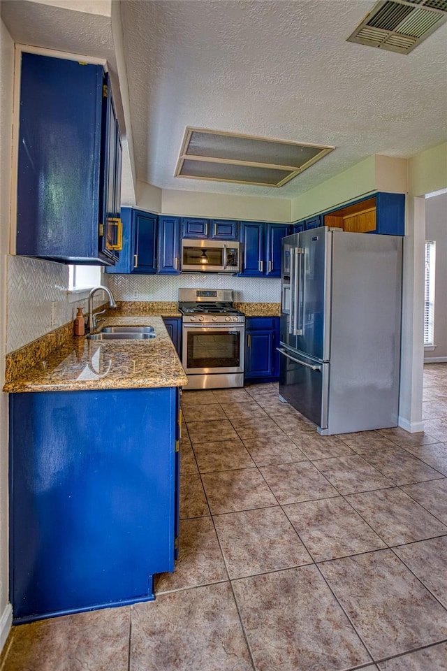 14715 Cobre Valley Dr, Houston, TX 77062 - kitchen featuring stainless steel appliances, blue cabinets, a textured ceiling, stone countertops, and tile patterned flooring