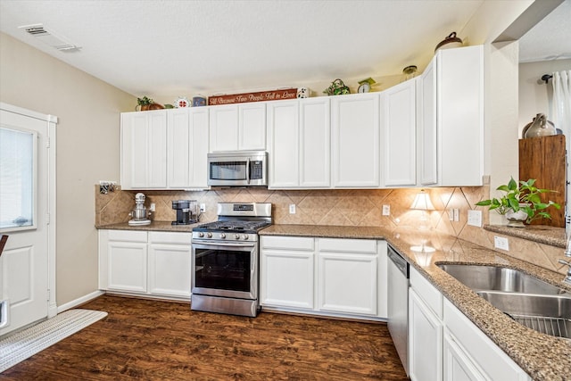 29708 Parliament Hills Dr, Spring, TX 77386 - kitchen with stainless steel appliances, backsplash, white cabinets, dark wood finished floors, and light stone counters
