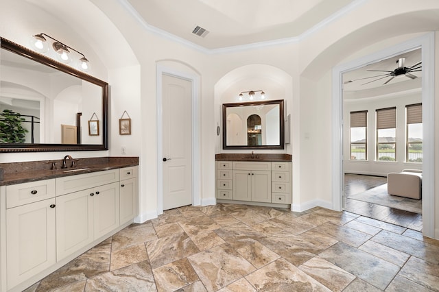 28106 Island Manor Ln, Fulshear, TX 77441 - full bathroom with crown molding, two vanities, a ceiling fan, and stone tile flooring