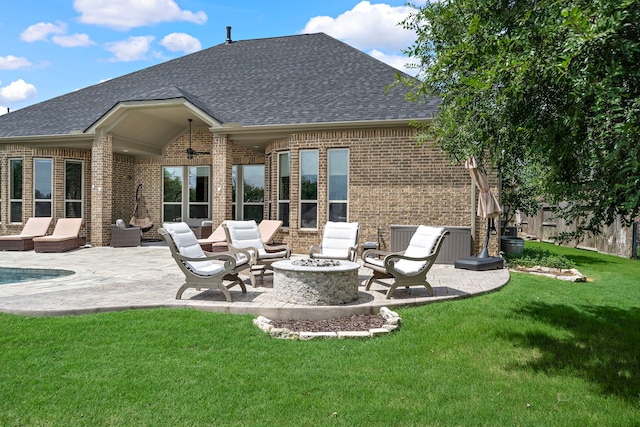 28106 Island Manor Ln, Fulshear, TX 77441 - back of property with brick siding, a shingled roof, a patio area, and an outdoor living space with a fire pit