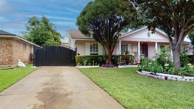 9030 Troulon Dr, Houston, TX 77036 - view of front of home featuring brick siding, a front yard, a gate, driveway, and covered porch