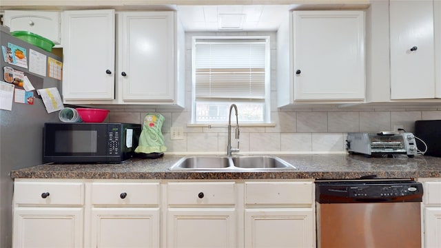 9030 Troulon Dr, Houston, TX 77036 - kitchen with appliances with stainless steel finishes, dark countertops, decorative backsplash, and white cabinets