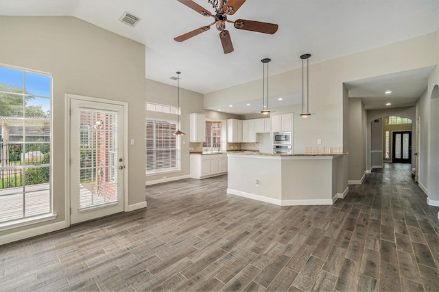 1123 Misty Lake Dr, Sugar Land, TX 77498 - kitchen with stainless steel appliances, a ceiling fan, white cabinets, arched walkways, and hanging light fixtures