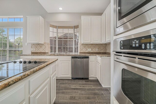 1123 Misty Lake Dr, Sugar Land, TX 77498 - kitchen with appliances with stainless steel finishes, tasteful backsplash, white cabinetry, light stone counters, and recessed lighting