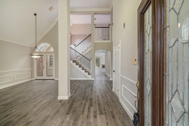 1123 Misty Lake Dr, Sugar Land, TX 77498 - foyer with stairway, dark wood-style floors, ornamental molding, arched walkways, and a wainscoted wall