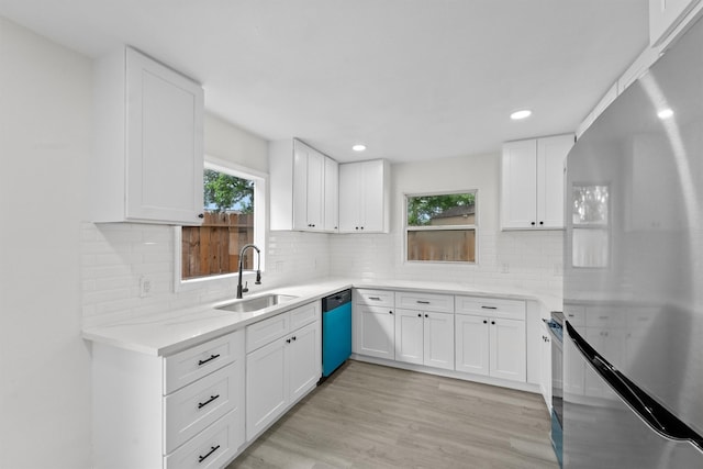 1615 Hiller St, Houston, TX 77015 - kitchen with freestanding refrigerator, dishwasher, white cabinetry, decorative backsplash, and light countertops