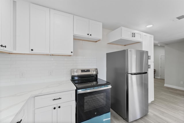 1615 Hiller St, Houston, TX 77015 - kitchen featuring appliances with stainless steel finishes, light stone countertops, white cabinets, light wood-style floors, and tasteful backsplash