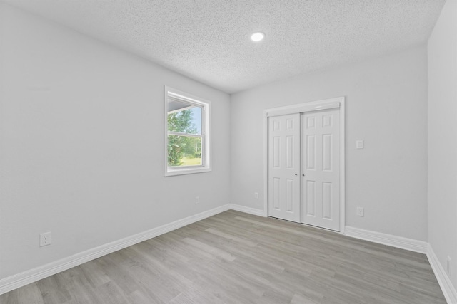 1615 Hiller St, Houston, TX 77015 - unfurnished bedroom featuring a textured ceiling, light wood-style flooring, a closet, and recessed lighting