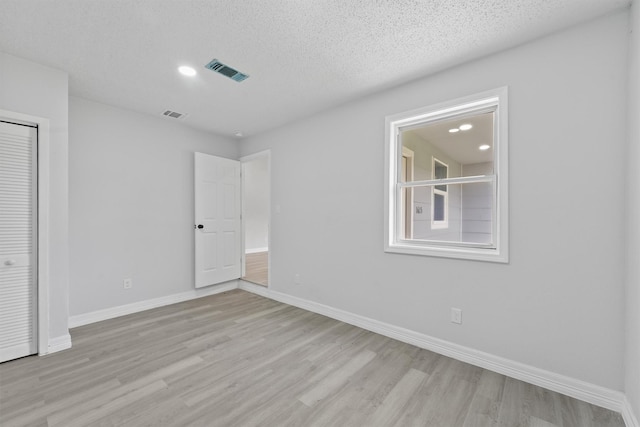 1615 Hiller St, Houston, TX 77015 - unfurnished bedroom featuring light wood finished floors, a closet, recessed lighting, and a textured ceiling
