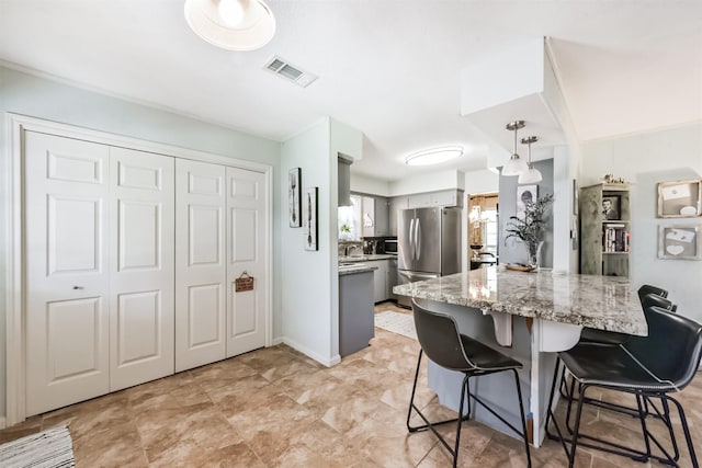 1721 Bowline Rd, Houston, TX 77062 - kitchen featuring appliances with stainless steel finishes, a breakfast bar area, gray cabinets, a peninsula, and light stone counters