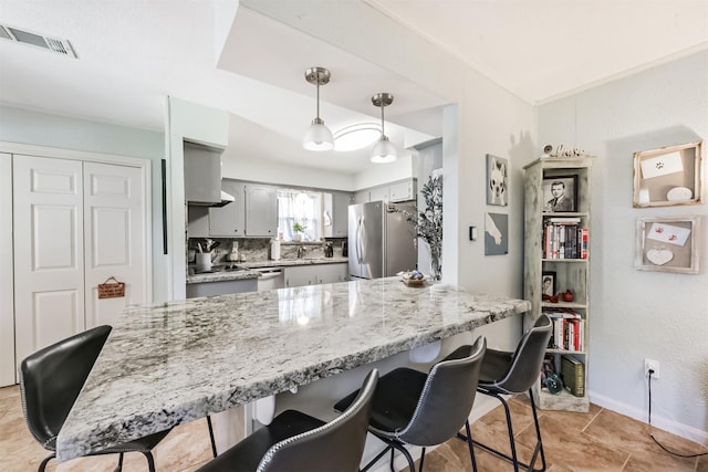1721 Bowline Rd, Houston, TX 77062 - kitchen with appliances with stainless steel finishes, a peninsula, gray cabinetry, a breakfast bar, and light tile patterned floors