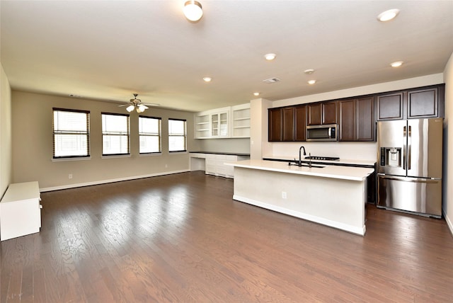 9428 Caddo Ridge Ln, Cypress, TX 77433 - kitchen with stainless steel appliances, light countertops, ceiling fan, dark brown cabinets, and an island with sink