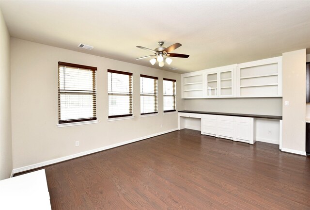 9428 Caddo Ridge Ln, Cypress, TX 77433 - unfurnished living room with built in study area, a ceiling fan, and dark wood-style flooring