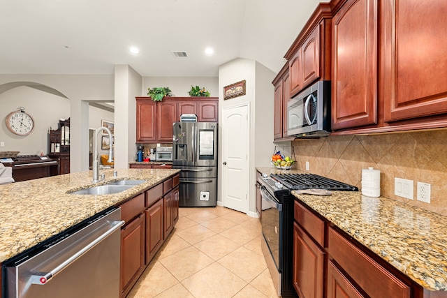 28215 Goose Creek Ct, Fulshear, TX 77441 - kitchen with stainless steel appliances, light stone countertops, decorative backsplash, light tile patterned flooring, and lofted ceiling