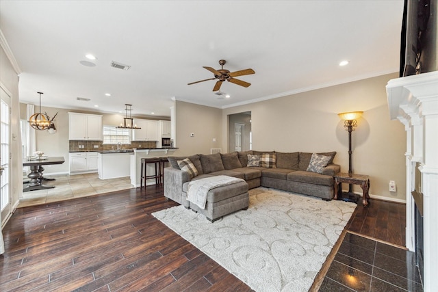 1440 Waseca St, Houston, TX 77055 - living room featuring a fireplace with flush hearth, crown molding, a ceiling fan, recessed lighting, and a chandelier