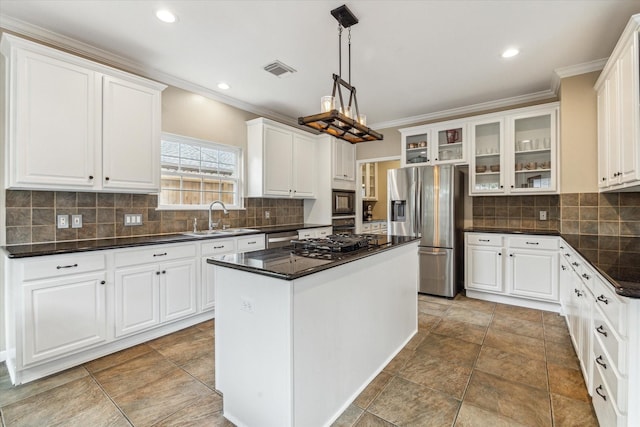 1440 Waseca St, Houston, TX 77055 - kitchen featuring stainless steel appliances, dark countertops, crown molding, a kitchen island, and glass insert cabinets