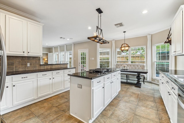 1440 Waseca St, Houston, TX 77055 - kitchen featuring appliances with stainless steel finishes, crown molding, decorative backsplash, a kitchen island, and recessed lighting