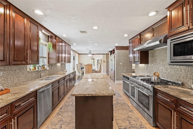 8220 Wateka Cir, Houston, TX 77074 - kitchen featuring appliances with stainless steel finishes, extractor fan, a center island, a ceiling fan, and backsplash