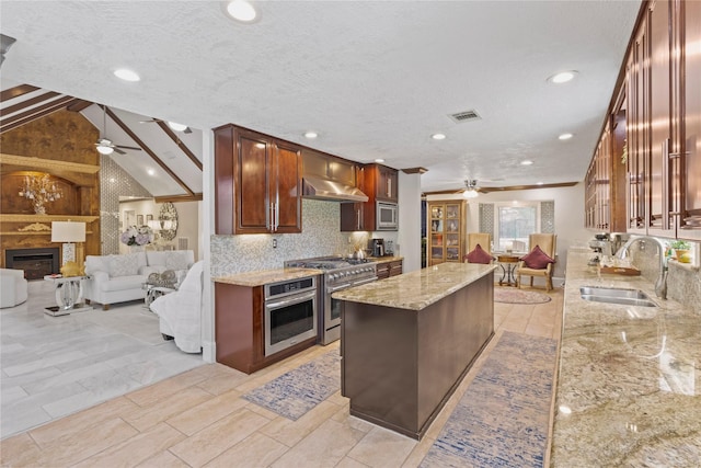 8220 Wateka Cir, Houston, TX 77074 - kitchen featuring ceiling fan, appliances with stainless steel finishes, open floor plan, light stone countertops, and decorative backsplash