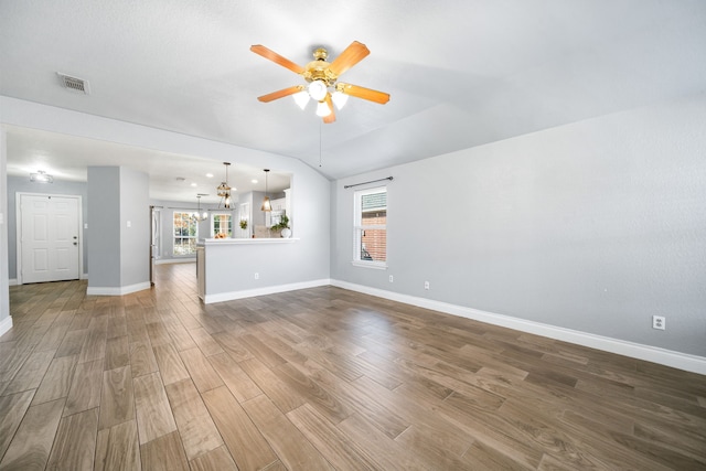 9710 Golden Park Ln, Houston, TX 77088 - unfurnished living room featuring ceiling fan, wood finished floors, a chandelier, and lofted ceiling