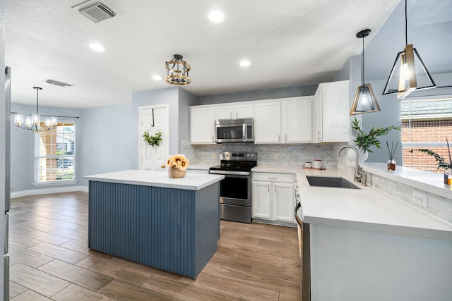 9710 Golden Park Ln, Houston, TX 77088 - kitchen featuring stainless steel appliances, a chandelier, tasteful backsplash, white cabinetry, and recessed lighting