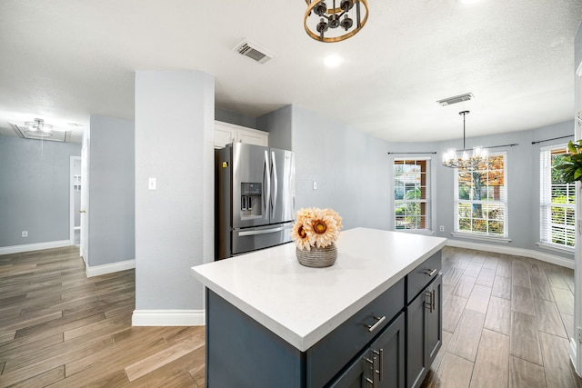 9710 Golden Park Ln, Houston, TX 77088 - kitchen with stainless steel fridge with ice dispenser, a chandelier, light wood-style floors, and light countertops
