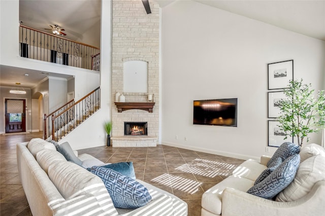 16206 Lakewood Field Dr, Tomball, TX 77377 - tiled living room with high vaulted ceiling, a fireplace, stairway, arched walkways, and a ceiling fan