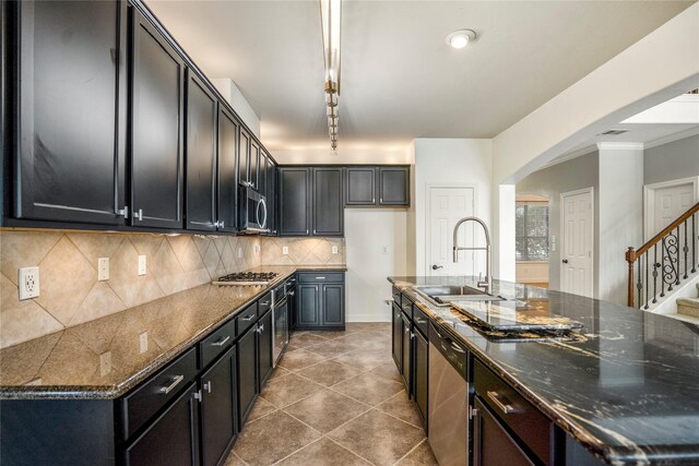 16206 Lakewood Field Dr, Tomball, TX 77377 - kitchen featuring stainless steel appliances, backsplash, arched walkways, dark stone countertops, and tile patterned floors