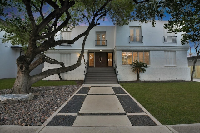 5110 Contour Pl, Houston, TX 77096 - view of front of house with a balcony, a front lawn, stucco siding, and brick siding