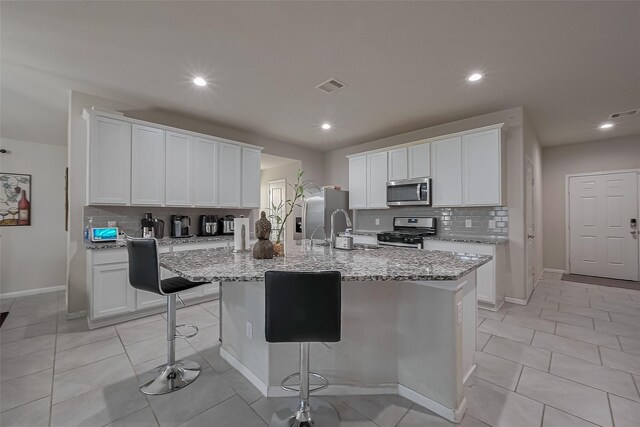 29626 Weber Way Ct, Katy, TX 77494 - kitchen with stainless steel appliances, backsplash, a kitchen island with sink, a kitchen breakfast bar, and recessed lighting