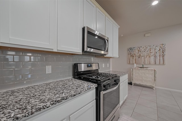 29626 Weber Way Ct, Katy, TX 77494 - kitchen featuring stainless steel appliances, decorative backsplash, stone counters, white cabinetry, and light tile patterned flooring