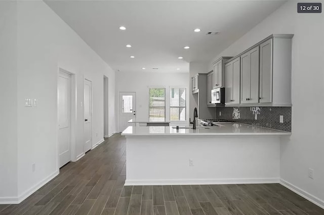 120 Lukewood Cir, Conroe, TX 77318 - kitchen featuring stainless steel microwave, gray cabinets, light countertops, dark wood-type flooring, and recessed lighting