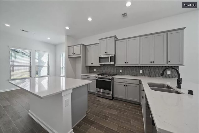 120 Lukewood Cir, Conroe, TX 77318 - kitchen with appliances with stainless steel finishes, gray cabinetry, tasteful backsplash, dark wood-style flooring, and recessed lighting