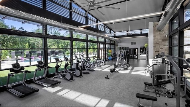 120 Lukewood Cir, Conroe, TX 77318 - exercise room featuring a towering ceiling, a ceiling fan, plenty of natural light, and carpet flooring