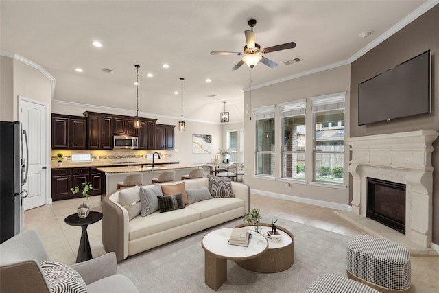 28647 Maple Red Dr, Katy, TX 77494 - living area featuring light tile patterned floors, ornamental molding, ceiling fan, a premium fireplace, and recessed lighting