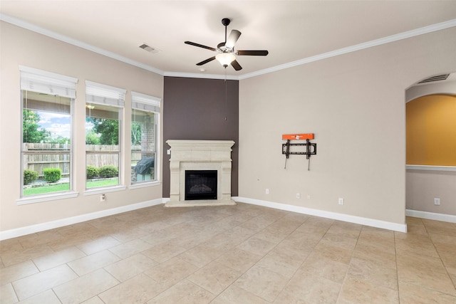 28647 Maple Red Dr, Katy, TX 77494 - unfurnished living room featuring a ceiling fan, ornamental molding, arched walkways, light tile patterned floors, and a glass covered fireplace