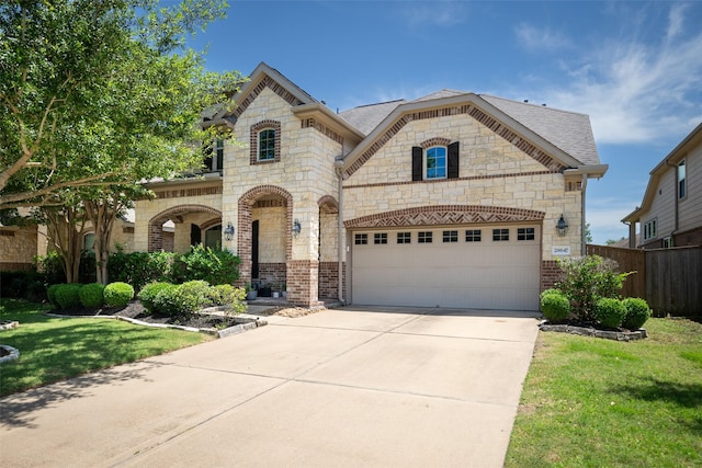 28647 Maple Red Dr, Katy, TX 77494 - french country inspired facade with brick siding, concrete driveway, stone siding, and roof with shingles