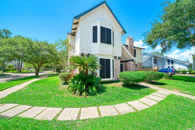 21434 Park Bluff Dr, Katy, TX 77450 - view of front facade featuring a front lawn, brick siding, and a chimney