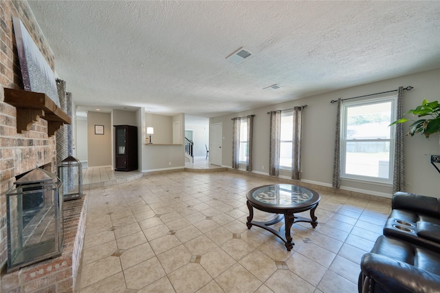 21434 Park Bluff Dr, Katy, TX 77450 - living area featuring a textured ceiling, a brick fireplace, and light tile patterned floors