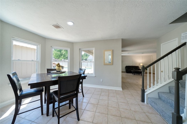 21434 Park Bluff Dr, Katy, TX 77450 - dining area with stairs, a textured ceiling, and light tile patterned floors