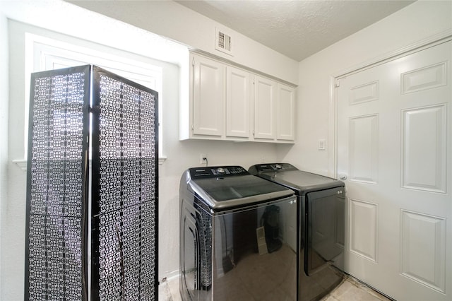 21434 Park Bluff Dr, Katy, TX 77450 - laundry room with independent washer and dryer, cabinet space, a textured ceiling, and light tile patterned floors
