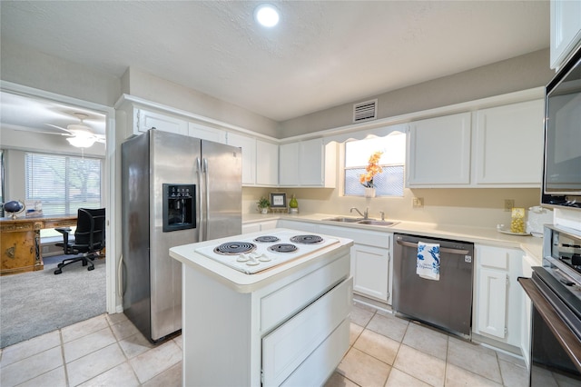 21434 Park Bluff Dr, Katy, TX 77450 - kitchen with appliances with stainless steel finishes, light countertops, a desk, white cabinetry, and a kitchen island